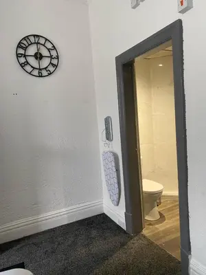 a bathroom with a clock on the wall and a toilet at Holiday Plus - Holmfield Road in Blackpool
