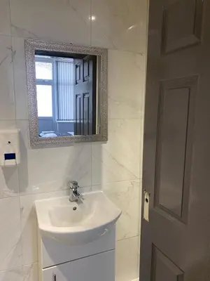 a white bathroom with a sink and a mirror at Holiday Plus - Holmfield Road in Blackpool