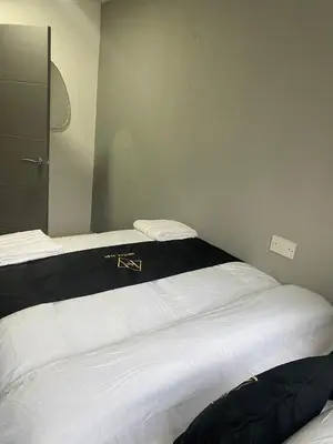 a bedroom with a bed with a black and white blanket at Holiday Plus - Holmfield Road in Blackpool