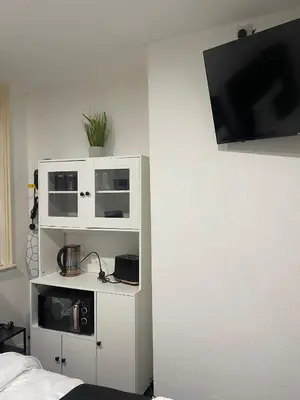 a bedroom with white cabinets and a tv on the wall at Holiday Plus - Holmfield Road in Blackpool