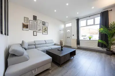 a living room with a couch and a table at Deluxe Bolton Cinema House 2BR Modern Retreat with Free Parking in Bolton