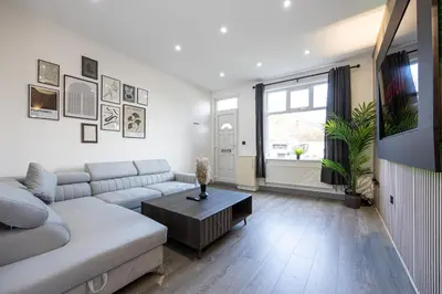 a living room with a couch and a table at Deluxe Bolton Cinema House 2BR Modern Retreat with Free Parking in Bolton