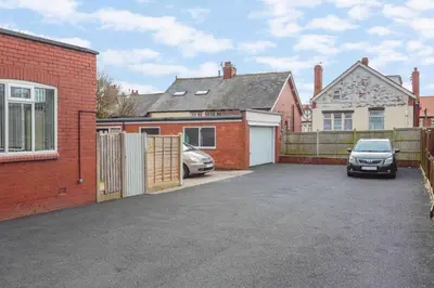 a car parked in a parking lot next to a house at Cherry Property - Blueberry Suite in Blackpool
