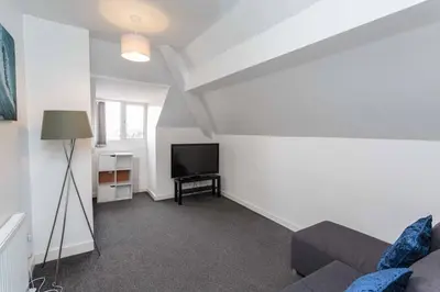 a living room with a couch and a flat screen tv at Cherry Property - Blueberry Suite in Blackpool