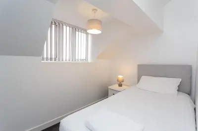 a white bedroom with a bed and a window at Cherry Property - Blueberry Suite in Blackpool
