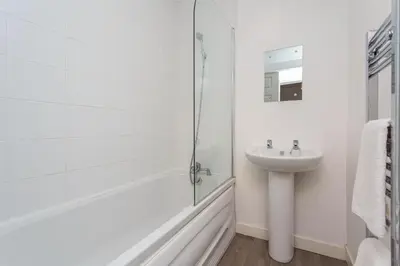 a white bathroom with a sink and a shower at Cherry Property - Blueberry Suite in Blackpool