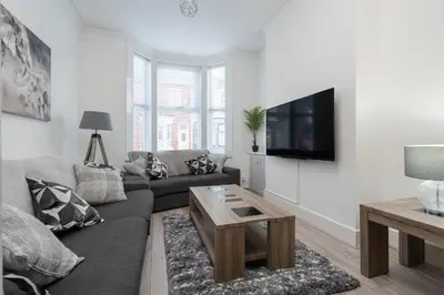 a living room with a couch and a tv on a wall at HORNSEY LODGE - Strictly NO Parties in Liverpool
