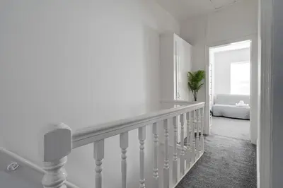a white staircase in a room with a couch at HORNSEY LODGE - Strictly NO Parties in Liverpool
