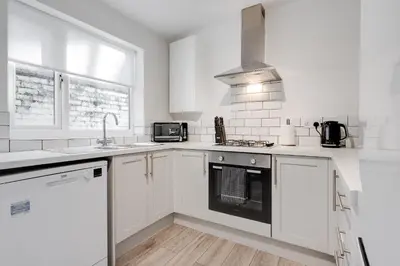 a white kitchen with a sink and a stove at HORNSEY LODGE - Strictly NO Parties in Liverpool