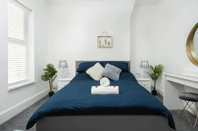 a bedroom with a blue bed with a stuffed animal on it at HORNSEY LODGE - Strictly NO Parties in Liverpool