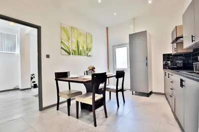 a kitchen and dining room with a table and chairs at Freckleton House in Town Centre, near Blackpool, Sleeps 6, Free Parking - By NMB Property in Kirkham