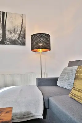 a bedroom with a bed and a lamp next to a couch at Freckleton House in Town Centre, near Blackpool, Sleeps 6, Free Parking - By NMB Property in Kirkham