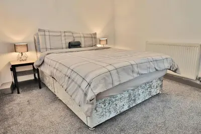 a bedroom with a bed and a table with a chair at Freckleton House in Town Centre, near Blackpool, Sleeps 6, Free Parking - By NMB Property in Kirkham