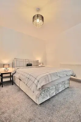 a white bedroom with a large bed and a chandelier at Freckleton House in Town Centre, near Blackpool, Sleeps 6, Free Parking - By NMB Property in Kirkham
