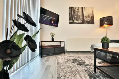 a living room with a tv and a couch at Freckleton House in Town Centre, near Blackpool, Sleeps 6, Free Parking - By NMB Property in Kirkham