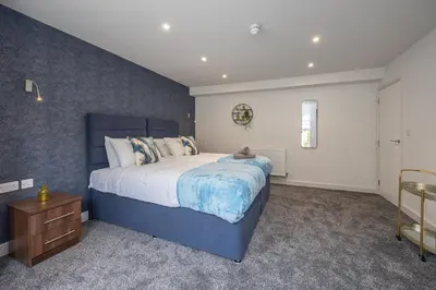 a bedroom with a blue bed with a teddy bear on it at Morecambe Bay Free Parking Beach Front in Morecambe
