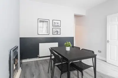 a dining room with a black table and chairs at Poppy's Project - July Road in Liverpool
