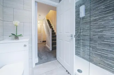a bathroom with a walk in shower and a staircase at Poppy's Project - July Road in Liverpool