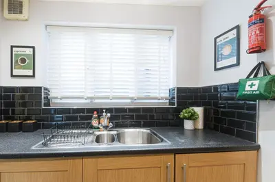 a kitchen counter with a sink and a window at Poppy's Project - July Road in Liverpool