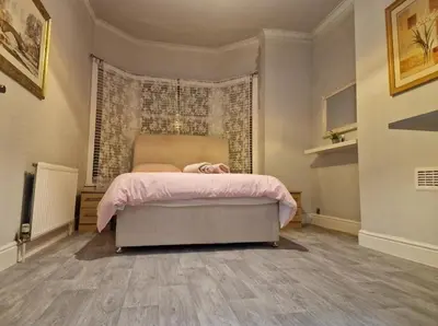 a bedroom with a bed with a pink blanket at ArklesFCLiverpool in Liverpool