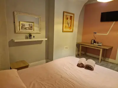 a bedroom with a bed with two towels on it at ArklesFCLiverpool in Liverpool