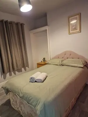 a bedroom with a bed with two towels on it at ArklesFCLiverpool in Liverpool