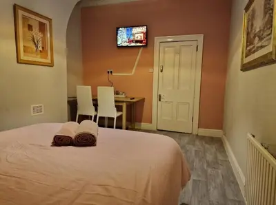 a bedroom with a bed with two towels on it at ArklesFCLiverpool in Liverpool