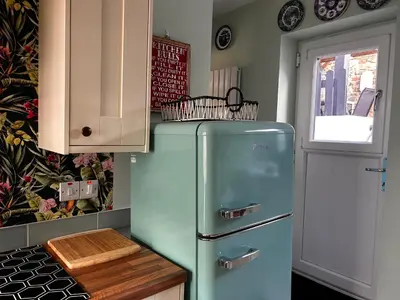 a blue refrigerator in a kitchen with a window at Historical Village Cottage - Pet Friendly in Heysham