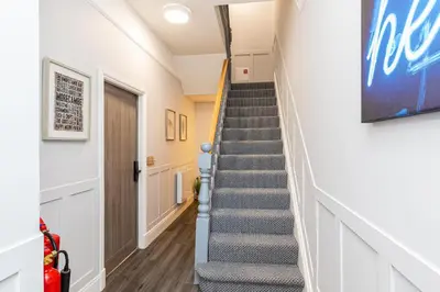 a staircase in a home with a blue stair case at Stylish Seafront Apartment - Sleeps 6 - Gateway to the Lakes in Morecambe
