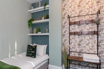 a room with a bed and a shelf with towels at Stylish Seafront Apartment - Sleeps 6 - Gateway to the Lakes in Morecambe