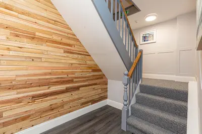 a wood paneled staircase in a home with a wooden accent wall at Stylish Seafront Apartment - Sleeps 6 - Gateway to the Lakes in Morecambe