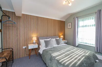 a bedroom with a large bed and a window at Seafront Apartment - Sleeps 6 - Gateway to the Lake District - Brand New in Morecambe