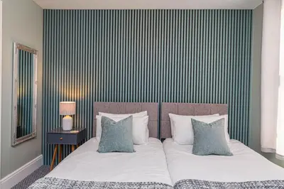 a bedroom with a bed with white sheets and pillows at Seafront Apartment - Sleeps 6 - Gateway to the Lake District - Brand New in Morecambe