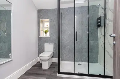 a bathroom with a toilet and a glass shower at Seafront Apartment - Sleeps 6 - Gateway to the Lake District - Brand New in Morecambe