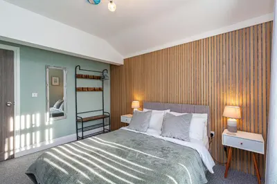 a bedroom with a bed and two lamps and a mirror at Seafront Apartment - Sleeps 6 - Gateway to the Lake District - Brand New in Morecambe
