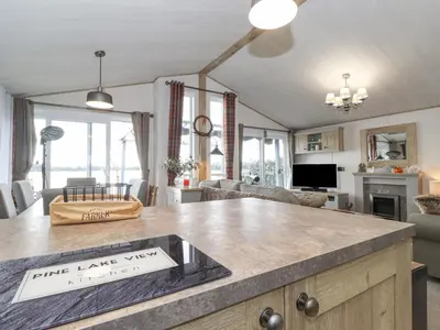 a kitchen and living room with a large island at Pine Lake View in Carnforth