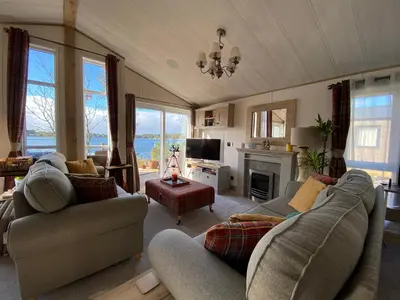 a living room with two couches and a fireplace at Pine Lake View in Carnforth