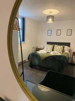 a bedroom with a bed and a mirror at Stylish Apartments near the sea front at Morecambe in Heysham