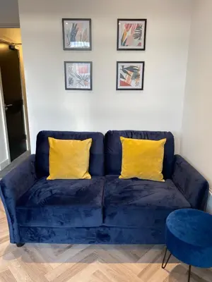 a blue couch with two yellow pillows in a living room at Stylish Apartments near the sea front at Morecambe in Heysham