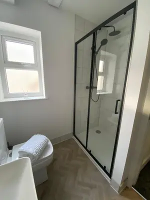 a bathroom with a shower with a toilet and a window at Stylish Apartments near the sea front at Morecambe in Heysham