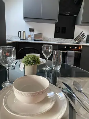 a kitchen with a table with a bowl and glasses at Stylish Apartments near the sea front at Morecambe in Heysham