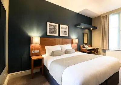 a bedroom with a large bed and a black wall at The County Hotel by Innkeeper's Collection in Lytham St Annes