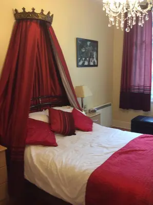 a bedroom with a bed with a red canopy at Beatles Apartment in Liverpool