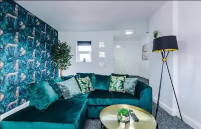 a living room with a green couch and a table at St Helens - Cosy 1 Bed in Saint Helens