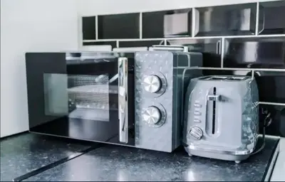 a microwave oven sitting on top of a kitchen counter at St Helens - Cosy 1 Bed in Saint Helens