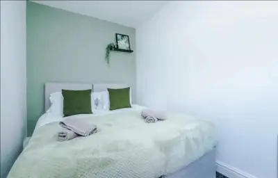a bedroom with a white bed with two stuffed animals on it at St Helens - Cosy 1 Bed in Saint Helens