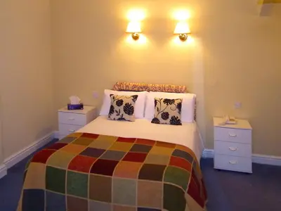 a bedroom with a bed with pillows and two night stands at The North Euston Hotel in Fleetwood