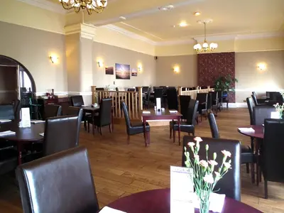 a dining room with tables and chairs in a restaurant at The North Euston Hotel in Fleetwood