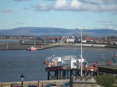 a dock with boats in a body of water at The North Euston Hotel in Fleetwood