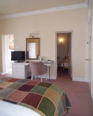 a bedroom with a bed and a desk with a television at The North Euston Hotel in Fleetwood